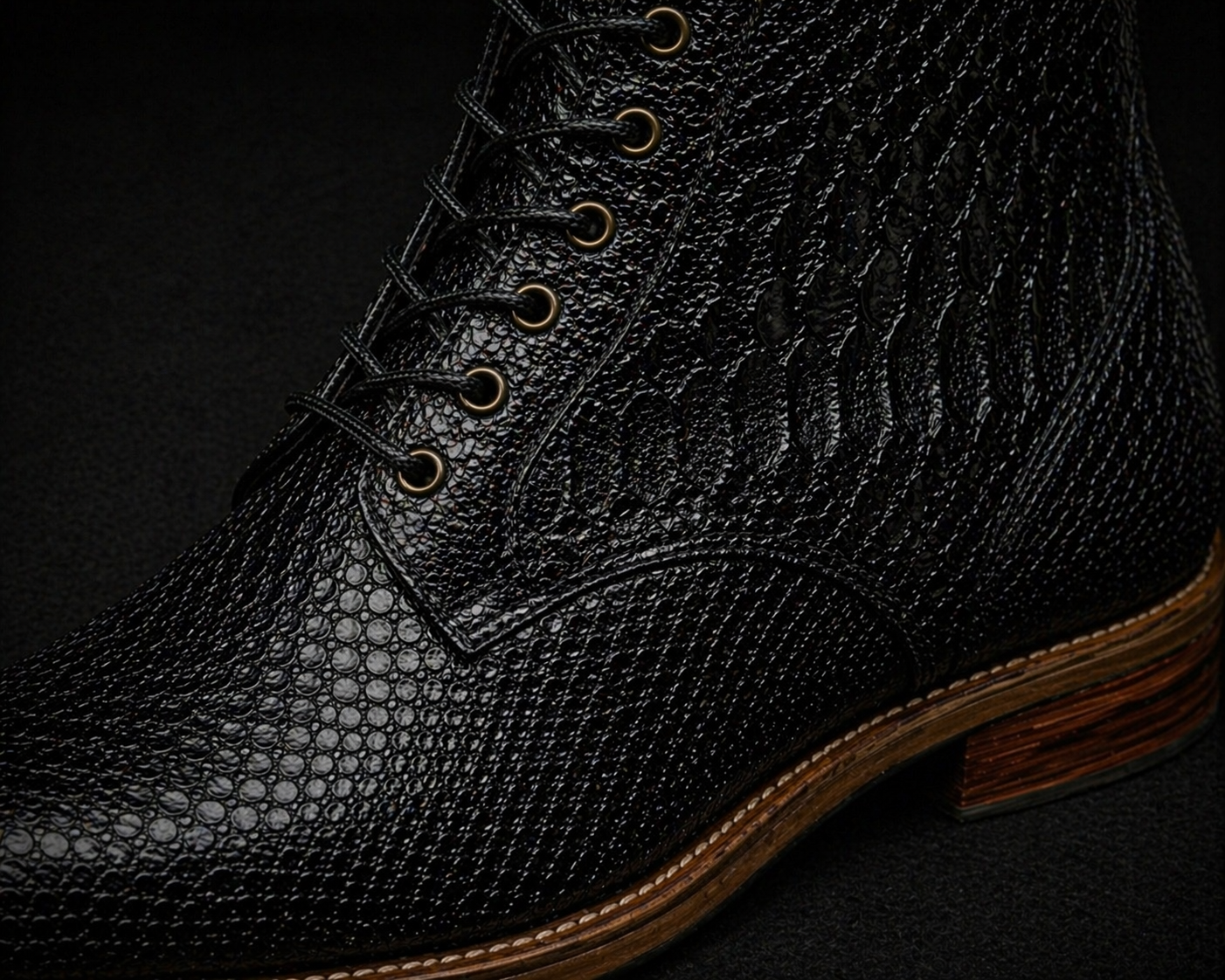 Close-up of a black leather boot with detailed texture on a dark background FOSSIL Dragon Tail Black Lace-Up Leather Dress Boot for Men - Kyoto Boots