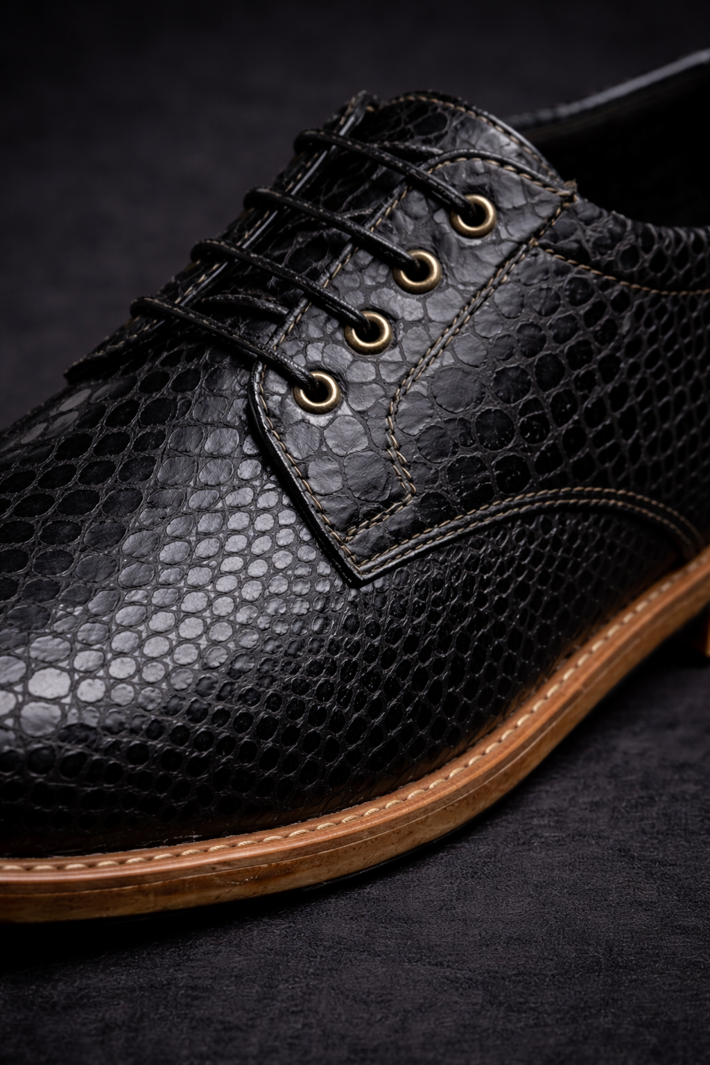 Black textured leather shoe with brown sole on a dark background FOSSIL Dendroaspis Black Textured Leather Derby Shoes for Men - Kyoto Boots
