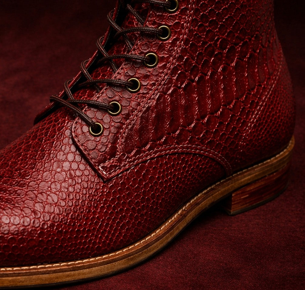 Close-up of a red leather boot with brown laces on a dark red background FOSSIL Dragon Blood Oxblood Red Lace-Up Leather Dress Boot for Men - Kyoto Boots
