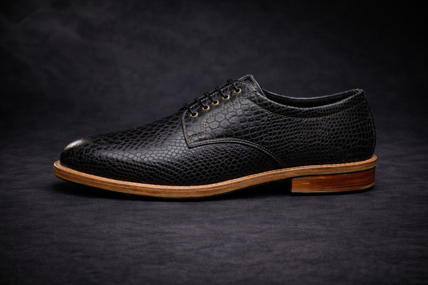 Black leather shoe with brown sole on a dark background FOSSIL Dendroaspis Black Textured Leather Derby Shoes for Men - Kyoto Boots